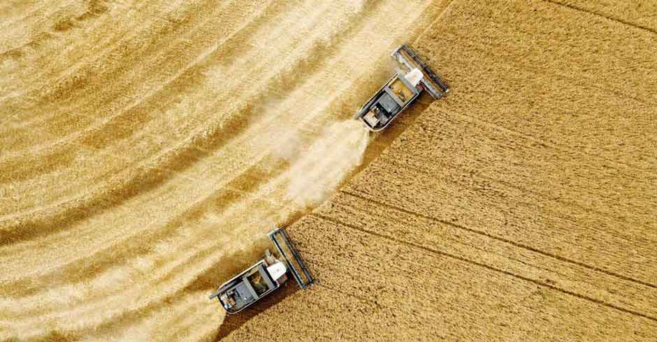 Aerial view of multiple harvesters operating in a crop field with telematics data, fleet monitoring, energy use tracking and digital twin based precision agriculture insights