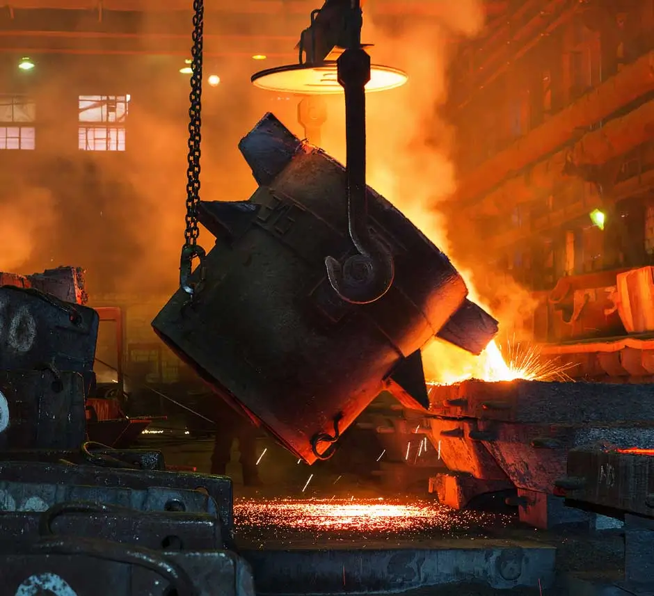 Steel smelting process with molten metal pouring from a ladle in a high temperature furnace environment monitored by SCADA systems, energy analytics and digital twin models