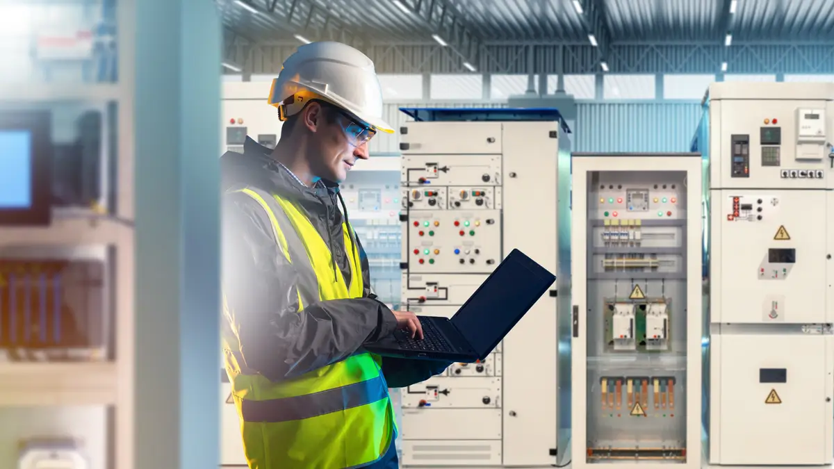 Industrial engineer checking electrical panels in power room using tablet for energy monitoring