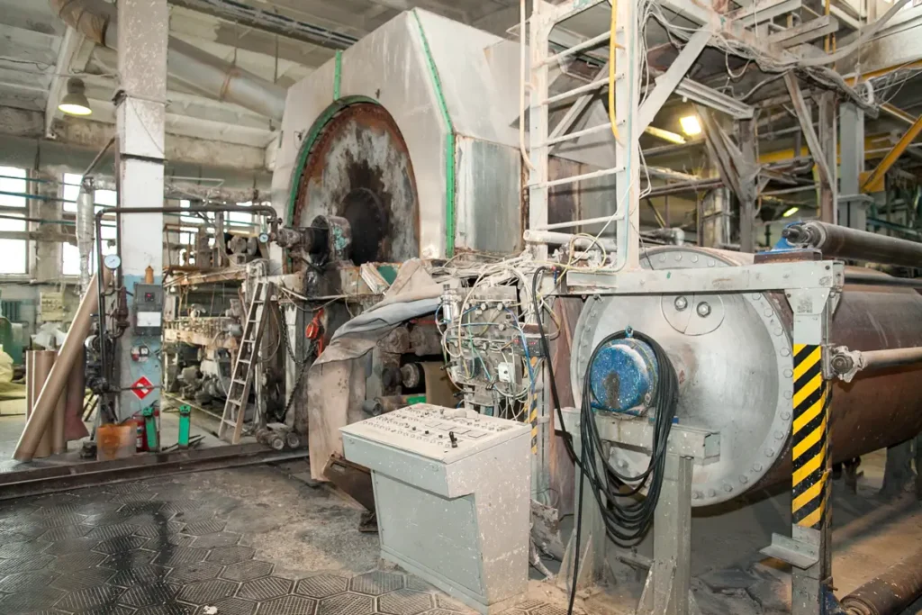 Equipos industriales legacy en una planta de producción mostrando un motor de gran tamaño y un sistema de proceso